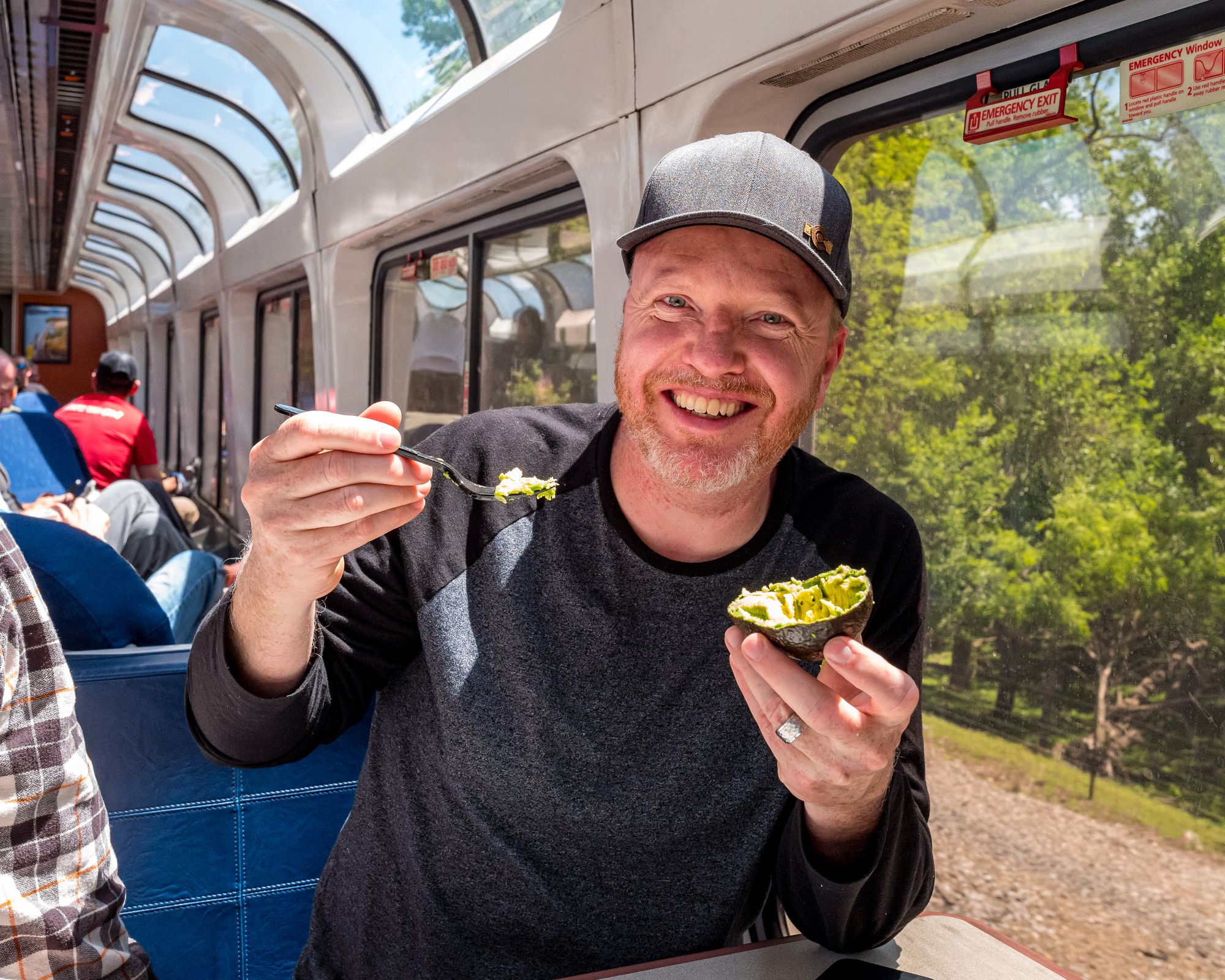 Amtrak Sightseer Lounge passenger eating an avocado and smiling