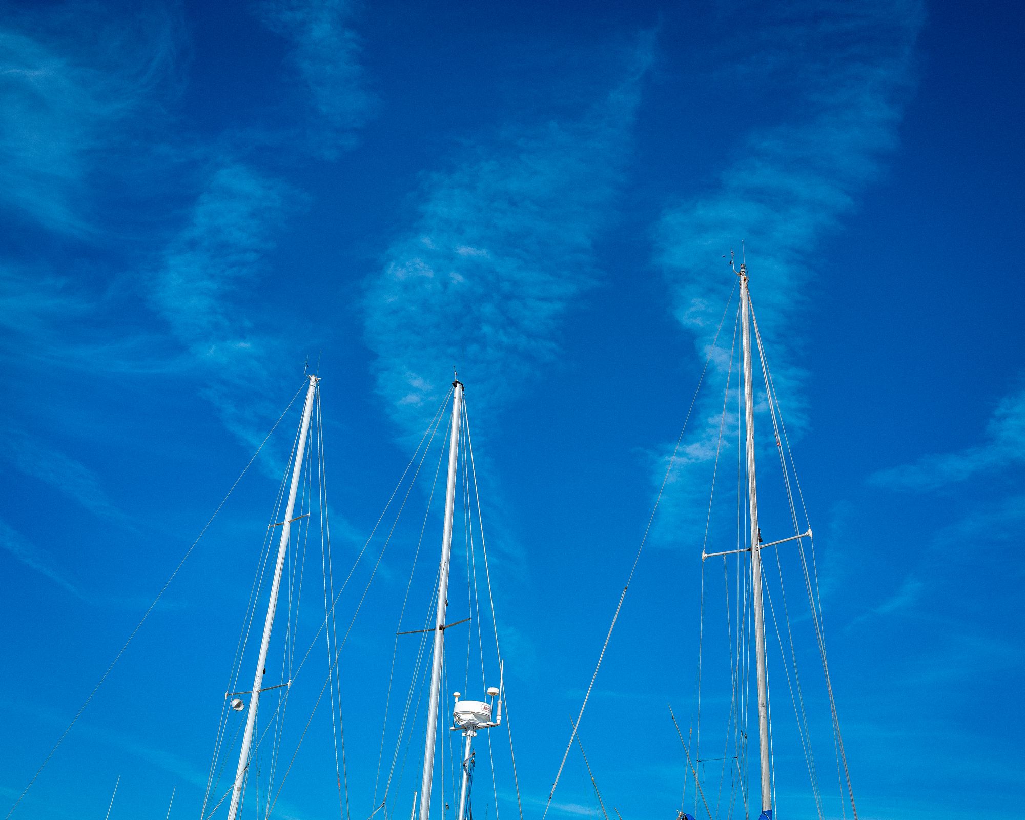 Three sailboat masts with three clouds Sayville Long Island New York